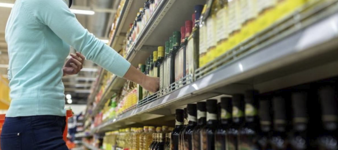 Persona comprando aceite de oliva Persona comprando aceite de oliva