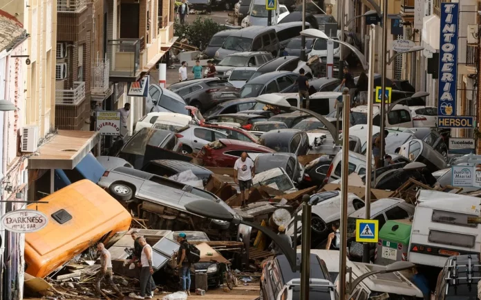 Una persona camina entre un grupo de coches arrastrados por la Dana en España. Una persona camina entre un grupo de coches arrastrados por la Dana en España.