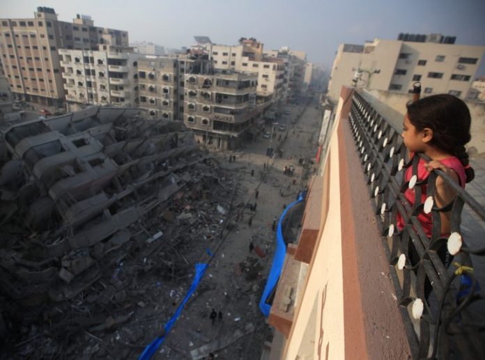 Una niña palestina observa edificio en ruinas en Gaza.